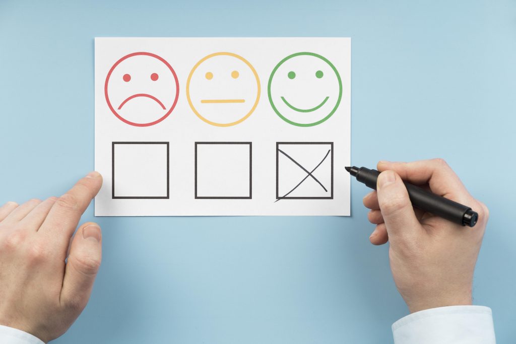 Drei Smilies mit verschiedenen Emotionen, darunter Kästchen zum Ankreuzen